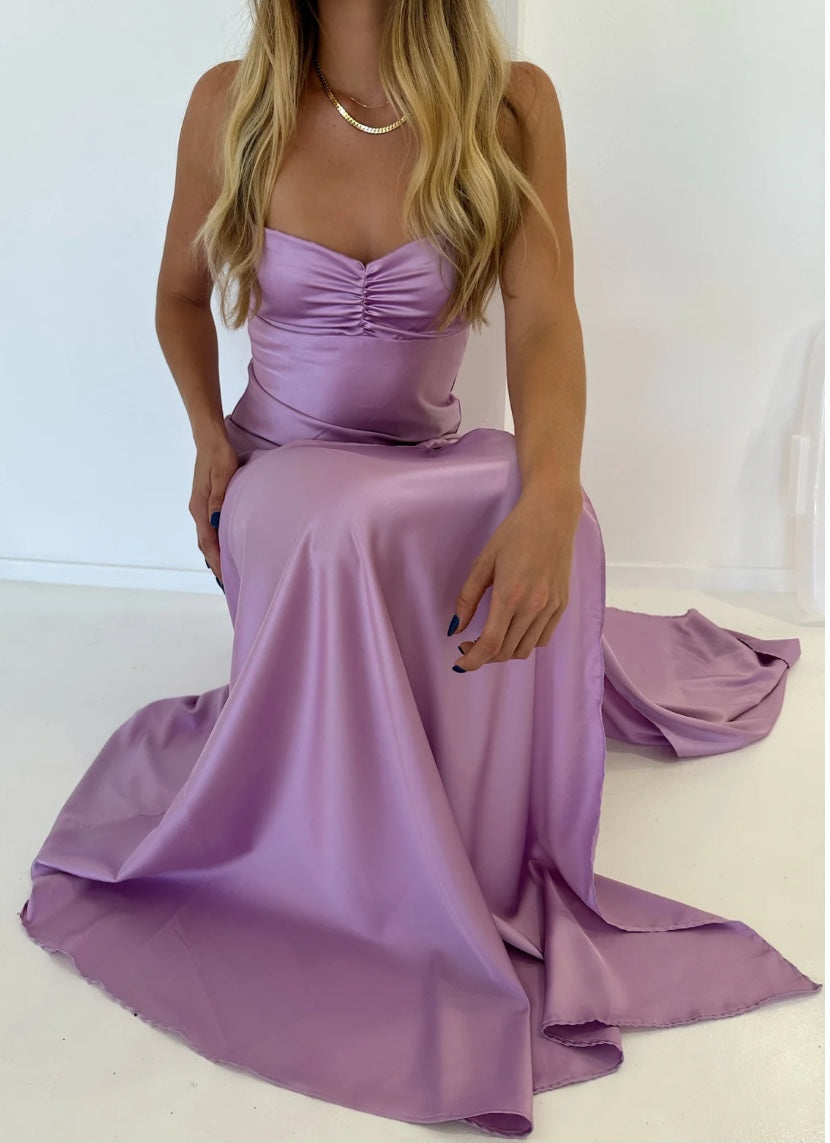 Hntr the label Gaia Gown in Lilac. Model is crouching on the ground with the full skirt covering her legs againast a white background. 